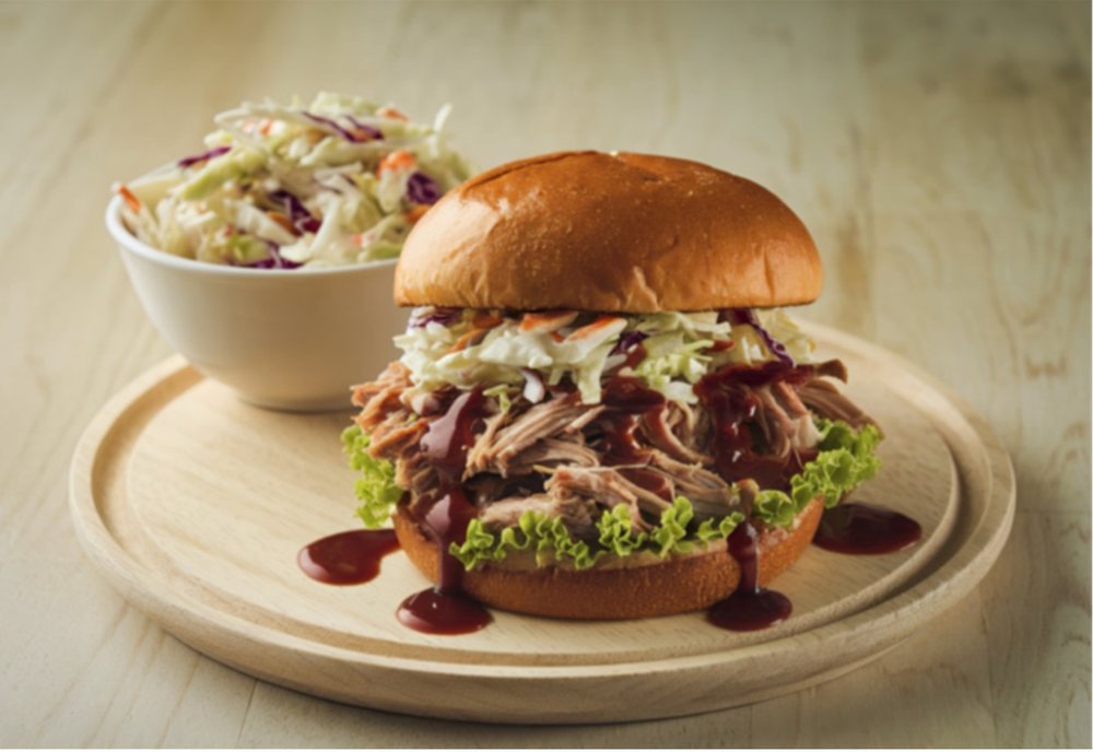 Pulled BBQ chicken sandwich with a bowl of coleslaw